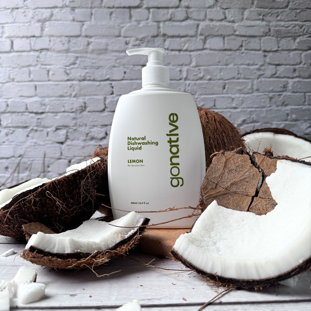 GoNative coconut-based natural dishwashing liquid, lemon, 500ml white pump bottle surrounded by fresh coconuts