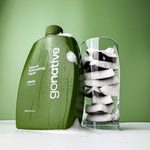 GoNative coconut-based natural dishwashing liquid, lemon, 500ml refill bottle with soap foam beside a glass of fresh coconut